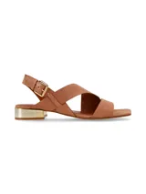 Sandalias de cuero color marrón tostado, con tiras asimétricas cruzadas, taco bajo rectangular con detalle metálico dorado y tira ajustable con hebilla en el talón.