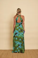 Vestido largo de satén con estampado abstracto en tonos verdes, azules y negros, escote halter y diseño fluido.