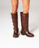 Botas altas de cuero marrón con acabado desgastado, múltiples hebillas metálicas laterales y tacón bajo cuadrado.
