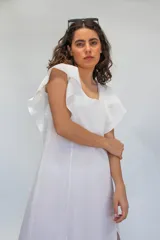 Vestido largo de algodón tusor en color blanco, con volados en las sisas que simulan mangas y aberturas laterales en la falda.