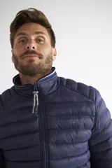 Campera puffer de nylon color azul marino, con cierre frontal completo, cuello alto y puños con detalle de rayas. Cuenta con bolsillos laterales con cierre y logo estampado en el pecho.