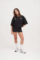 Camiseta negra de manga corta con cuello en V, corte holgado y cordón ajustable en la cintura.