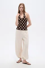 Top de punto al cuerpo con cuello halter, color beige con estampado de lunares marrones.
