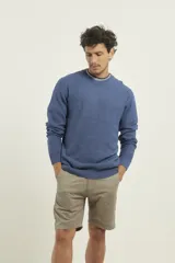 Sweater de punto fino azul con cuello redondo y terminaciones elásticas en canalé.