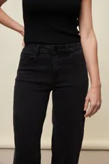 Jeans de corte straight y tiro medio, color negro, confeccionados en denim con spandex. Presenta un sutil tajo en la parte inferior del ruedo.