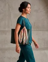 Pañuelo cuadrado de satén con estampado geométrico y floral en tonos turquesa, naranja, azul y beige.