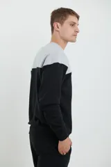 Sweater deportivo de hombre con escote redondo, diseño colorblock con la parte superior en gris claro y el cuerpo y mangas en negro. Presenta puños y cintura elastizados.