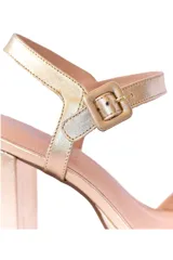 Sandalias de taco alto y plataforma color oro claro, con tiras en la parte delantera y tira ajustable con hebilla en el tobillo.