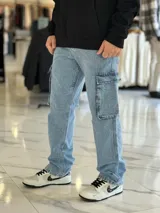 Pantalón de jean cargo color azul, con bolsillos laterales con solapa en los muslos, corte recto y holgado.