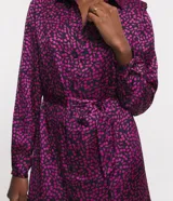 Vestido corto chemise en crepé con estampado de mini cerezas, cuello camisero, abotonado delantero, manga larga y lazo en la cintura.