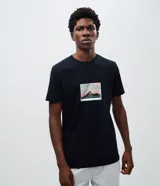 Remera de algodón color negro, de manga corta y cuello redondo, con estampa fotográfica localizada en el pecho.