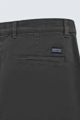 Pantalón chino de corte ajustado, color beige, con bolsillos laterales y bolsillos traseros de vivo. Cuenta con cierre frontal de cremallera y botón.
