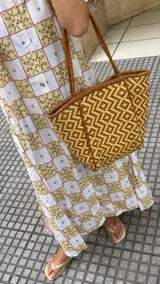 Bolso tipo tote de cuero trenzado color tostado con diseño geométrico.