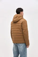 Campera de gabardina capitoneada con interior forrado en nylon. Presenta capucha fija, bolsillos frontales en el pecho con solapa y bolsillos laterales con cierre. Cuenta con cierre frontal central.