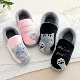 Pantuflas cerradas de color azul con diseño de gatito, confeccionadas en piel sintética suave con interior de peluche gris. Presentan un bordado con la frase 'Welcome Home' y apliques de patitas de gato. Cuentan con suela de goma antideslizante.