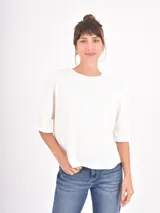 Remera negra de corte holgado, con cuello redondo y mangas cortas con dobladillo ancho.