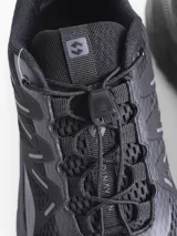 Championes de estilo outdoor color negro, con capellada de malla transpirable y refuerzos sintéticos. Presentan sistema de ajuste rápido con cordón elástico y suela de goma con relieve para mayor tracción.