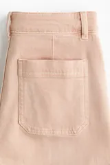 Jean amplio de tiro alto confeccionado en denim de algodón color rosado, con bolsillos frontales de parche y raya marcada al frente y en la espalda.