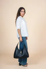 Blusa blanca de algodón con bordado delicado en relieve, corte amplio, botones al frente y cuello redondeado.