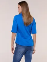 Camisa roja de poplín de algodón, de silueta semi entallada con cuello camisero y escote en V. Cuenta con cierre frontal de botones metálicos, bolsillos plaqué en el pecho y mangas 3/4 arremangables con presilla y argolla metálica.