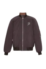 Campera bomber color marrón oscuro con cuello alto, puños y ruedo acanalados. Estampado en la espalda con la palabra "Bestia" en letras góticas.