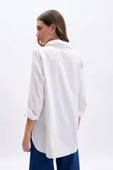 Camisa blanca de manga larga con cuello camisero y pespuntes contrastantes en color crudo.