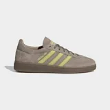 Championes Adidas modelo Handball Spezial, confeccionados en gamuza color marrón con las icónicas tres rayas laterales y detalles en color verde lima. Presentan suela de caucho color caramelo y el logo Spezial en el lateral.