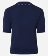 Blusa negra de punto con cuello polo, escote en V y mangas cortas. Detalle de mini perlas aplicadas en el cuello.