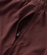 Bermuda deportiva color bordó con short interno de compresión negro integrado. Cuenta con cintura elástica con cordón de ajuste, bolsillos laterales con cierre y bolsillo interno. Confeccionada en tejido técnico de secado rápido.