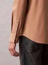 Camisa de manga larga Calvin Klein con corte slim, cuello de punta clásico, cierre frontal con botones a tono y monograma bordado sutilmente en el pecho.