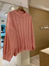 Sweater tejido color salmón con cuello redondo y diseño de ochos.