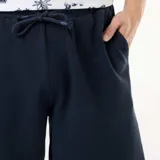 Bermuda azul marino de felpa ligera con cintura elástica ajustable mediante cordón y bolsillos laterales.