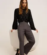 Pantalón de sastrería corte wide leg, color gris oscuro, con cintura alta, pliegues frontales, bolsillos laterales y trabillas para cinturón. Incluye un cinturón fino de material sintético con hebilla metálica.