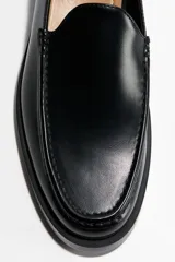 Mocasines de diseño clásico en color negro, con costura tradicional en la parte superior y suela de goma.