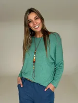 Sweater de tejido de punto color verde agua, con cuello redondo, mangas largas y diseño holgado con caída fluida.
