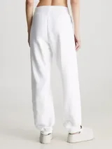 Jogger de felpa blanco, corte relaxed, con cintura elástica, puños de canalé y bolsillos con ranura. Presenta un monograma acolchado de Calvin Klein en relieve en la pierna.
