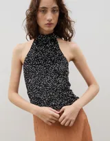 Top halter de cuello alto, confeccionado en tejido negro con acabado brillante y textura sutil.