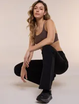 Legging deportiva negra de tiro alto, confeccionada en tejido de alta densidad, con ajuste entallado en los muslos y diseño acampanado desde la rodilla hacia el ruedo. Cuenta con una pretina ancha lisa que brinda soporte y contención abdominal.