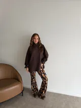 Poleron de punto color marrón chocolate, con cuello alto, mangas largas abullonadas con puños elásticos y diseño holgado de corte largo.