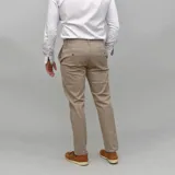 Pantalón de gabardina color azul marino, de corte ajustado y tiro medio, con cierre y botón frontal.