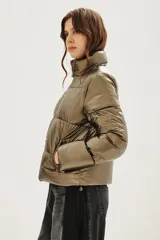 Campera puffer de cuello alto con cierre frontal, acabado metalizado y bolsillos laterales con cierre.