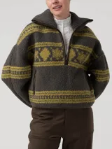 Sweater polar de cuello alto y cierre medio con detalles en cuero sintético, de color verde oscuro con estampado de patrones tradicionales en tono verde claro. Cuenta con mangas largas y diseño holgado.