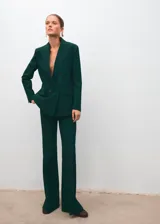 Blazer de corte recto y diseño estructurado, confeccionado en tejido mezcla de lana color verde oscuro. Presenta cuello con solapas de muesca, cierre frontal de doble botonadura, bolsillos de solapa laterales y bolsillo de ribete en el pecho. Incluye forro interior y mangas largas con puños abotonados.