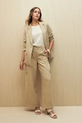 Pantalón de tiro alto color beige, de corte wide leg y doble bolsillo.