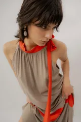 Vestido largo color marrón con detalles en tono marfil, escote halter y lazo largo en el cuello.