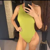 Traje de baño enterizo color verde, de corte semivedetina y con almohadillas desmontables. Diseño de un solo hombro.