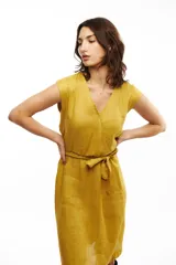 Vestido midi de lino color mostaza, con escote cruzado tipo kimono y lazo en la cintura.
