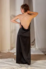 Vestido largo de satén negro con espalda descubierta y breteles finos cruzados en la espalda.