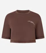 Remera deportiva Get Over de corte cropped y calce suelto, confeccionada en poliamida. Presenta manga corta, escote redondo y estampa frontal con texto en el pecho. Incluye una abertura vertical en la espalda para mayor ventilación.