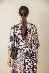 Vestido midi italiano cruzado en satén de seda estampado con cintura elastizada y lazo. Tiene mangas tres cuartos con presilla y terminación de volado en el bajo.